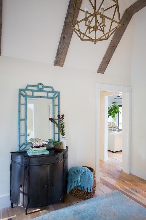 vaulted-foyer-ceiling-black-half-moon-table-blue-bamboo-mirror