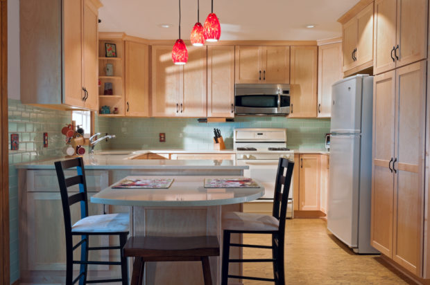 A newly remodeled kitchen interior with cork floors, maple cabinets, and a glass-tile backsplash. Pic: Shutterstock