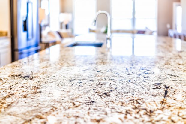 New modern faucet and kitchen room sink closeup with island and granite countertops in model house, home, apartment New modern faucet and kitchen room sink closeup with island and granite countertops in model house, home, apartment