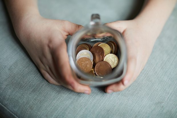 Little boy saving money in a jar