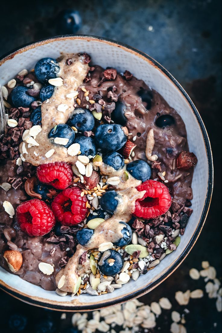 Porridge with sesame and coconut milk, topped with berries and seeds
