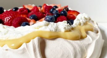 Meringue cake in a pan with lemon curd and all the berries of the summer